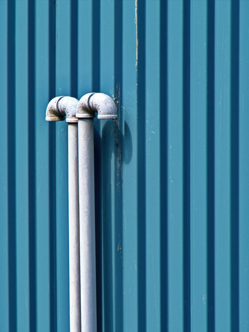 White pipes on a blue building wall