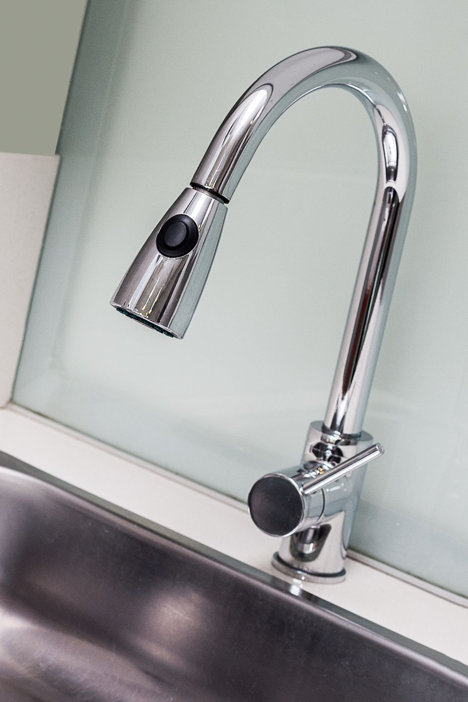 Chrome kitchen faucet over a steel sink